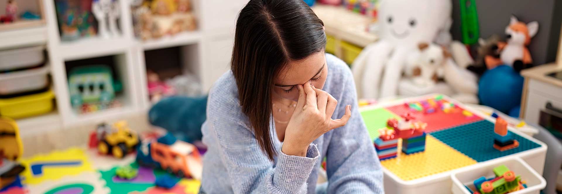 Maestra en salón de clases con dolor de cabeza