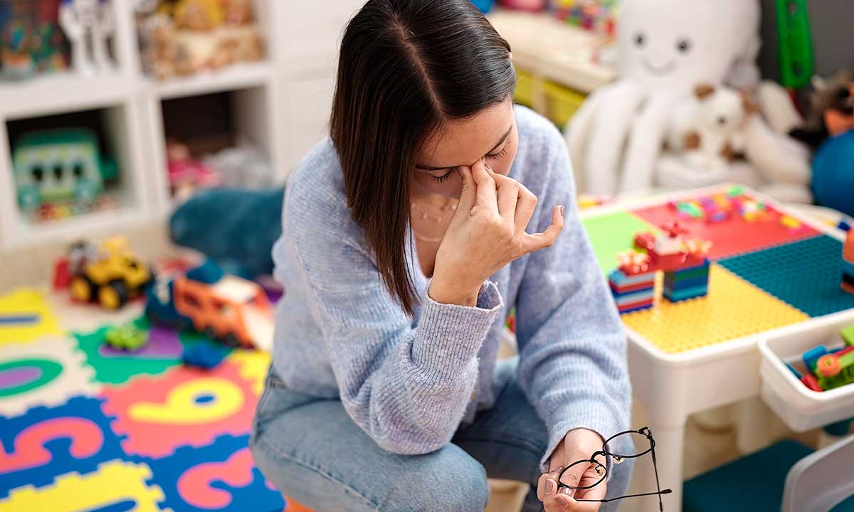 Maestra en salón de clases con dolor de cabeza